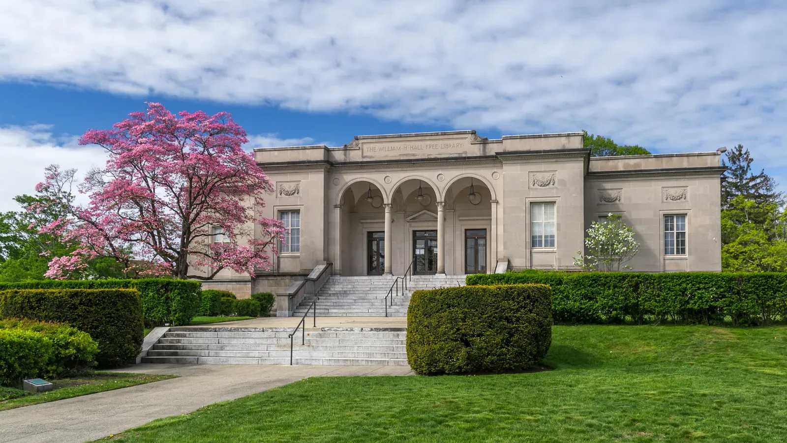 The neoclassical William H. Hall Free Library with a flowering tree, Cranston, Rhode Island